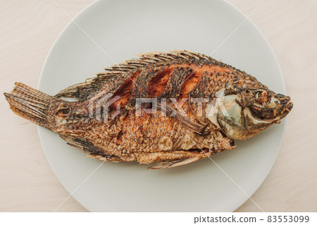 Thai fired fish served on white dis wooden table. Thai fired fish served on white dis wooden table. 83553099