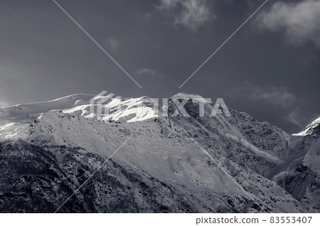 Black and white snowy sunlight mountains, view from off piste slope Black and white snowy sunlight mountains, view from off piste slope 83553407