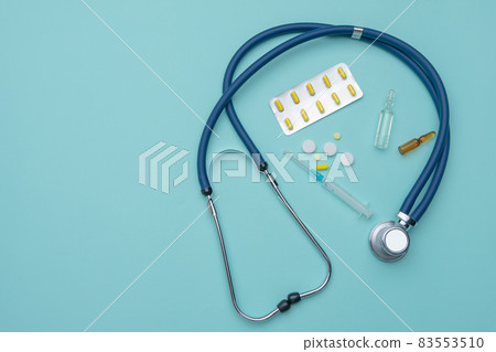A stethoscope, ampoules, a syringe, a mask and tablets. Medical concept. 83553510