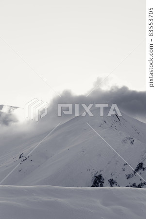 Black and white snowy off-piste slope in high mountains at winter evening 83553705