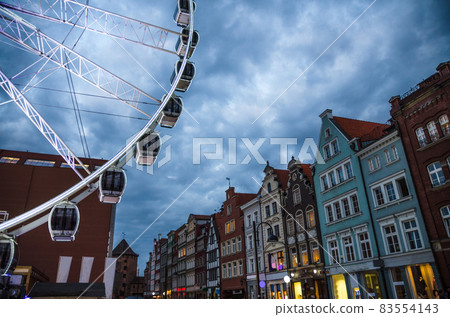 Big ferris wheel, buildings and tower Brama Stagiewna, Gdansk, Poland Big ferris wheel, buildings and tower Brama Stagiewna, Gdansk, Poland 83554143