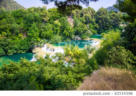 Waterfalls among green plants in Krka National Park, Dalmatia, Croatia 83554396