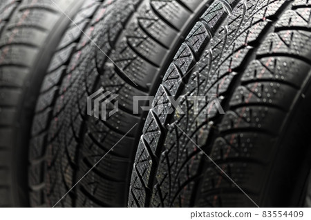 Clean car tyres spinning against dark background Clean car tyres spinning against dark background 83554409
