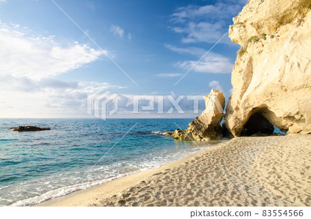 Rock with arch gate cave greenery near sandy beach, Tropea, Italy 83554566