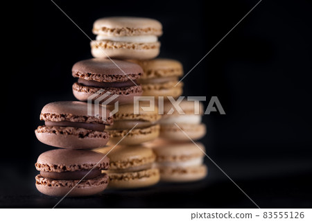 chocolate, coffee, vanilla, lemon and strawberry macaroons on black background chocolate, coffee, vanilla, lemon and strawberry macaroons on black background 83555126