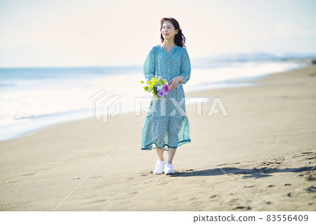 Young woman walking on a sandy beach Young woman walking on a sandy beach 83556409