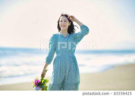 Young woman walking on a sandy beach Young woman walking on a sandy beach 83556425