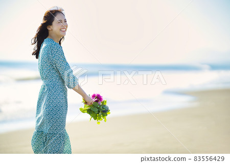 Young woman walking on a sandy beach Young woman walking on a sandy beach 83556429