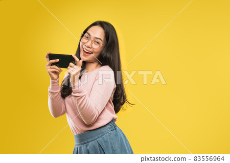 beautiful woman laughing looking at the screen of a smartphone beautiful woman laughing looking at the screen of a smartphone 83556964