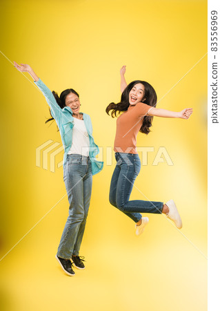 two young woman happy smile jump up celebrate success with raise hands two young woman happy smile jump up celebrate success with raise hands 83556969