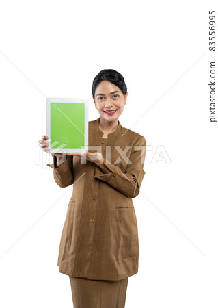 Attractive woman wearing khaki uniform smiling showing her tablet screen Attractive woman wearing khaki uniform smiling showing her tablet screen 83556995