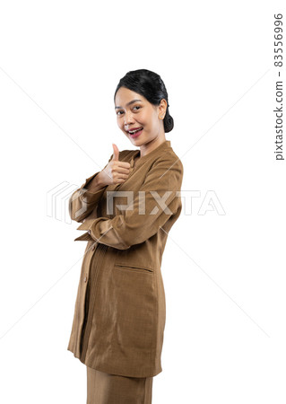 Smiling young civil servant woman standing with thumbs up Smiling young civil servant woman standing with thumbs up 83556996