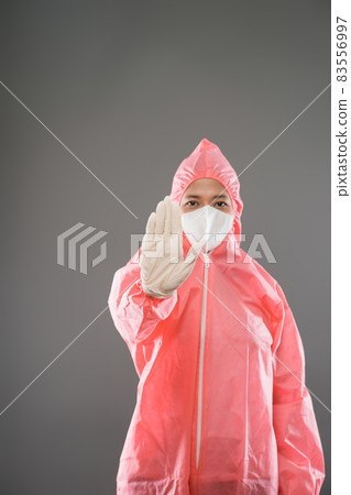 Health worker wear personal protective equipment with palms forward as a stop gesture Health worker wear personal protective equipment with palms forward as a stop gesture 83556997