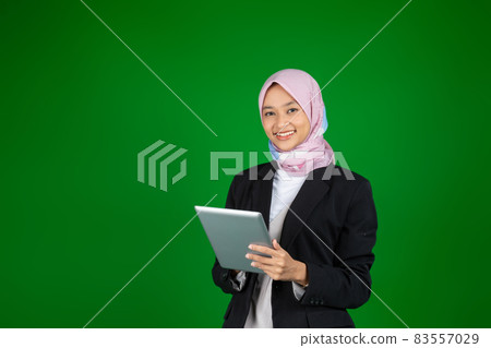 Muslim girl in hijab using a digital tablet with copyspace Muslim girl in hijab using a digital tablet with copyspace 83557029