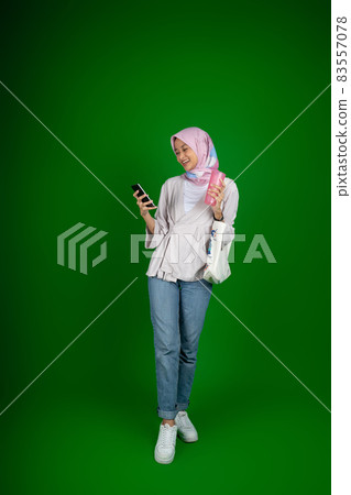 Excited asian muslim woman while using a mobile phone and credit card Excited asian muslim woman while using a mobile phone and credit card 83557078