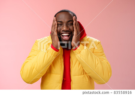 Happy charismatic playful african american bearded guy in yellow jacket red hoodie press palms cheeks smiling friendly laughing happily joking cannot believe receive awesome surprise, winning lottery Happy charismatic playful african american bearded guy in yellow jacket red hoodie press palms cheeks smiling friendly laughing happily joking cannot believe receive awesome surprise, winning lottery 83558916