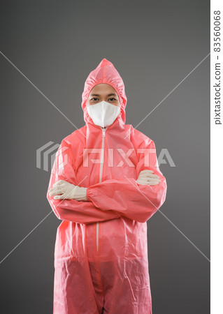 female health worker standing with half body portrait in red PPE and a mask when folded hands female health worker standing with half body portrait in red PPE and a mask when folded hands 83560068