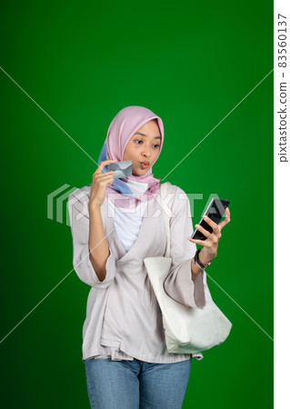 Woman in hijab happy using mobile phone for video call Woman in hijab happy using mobile phone for video call 83560137