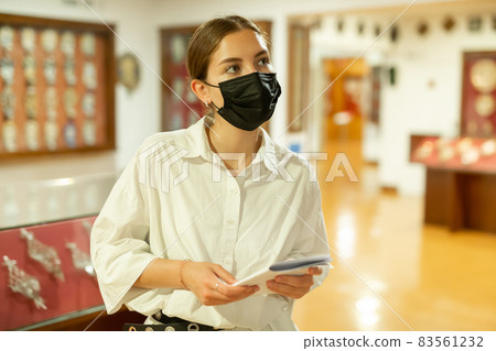 Woman wearing face mask observing artworks in museum 83561232