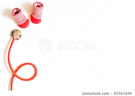 Children's doctor concept - red little baby shoes with stethoscope on white background top view copy space 83561844