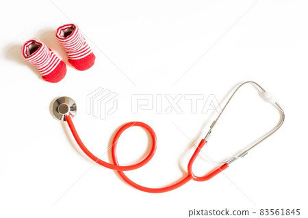 Children's doctor concept - red little baby shoes with stethoscope on white background top view copy space 83561845