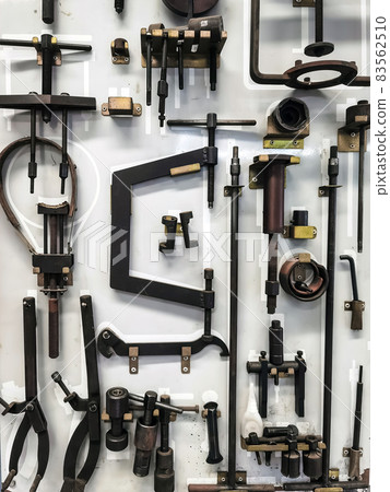 Many tools for repairing motorcycles hanging on wall in workshop. Set Craftsman tool , mechanical tools. Professional mechanic using different tools for working in motorbike repair service at garage. Many tools for repairing motorcycles hanging on wall in workshop. Set Craftsman tool , mechanical tools. Professional mechanic using different tools for working in motorbike repair service at garage. 83562510