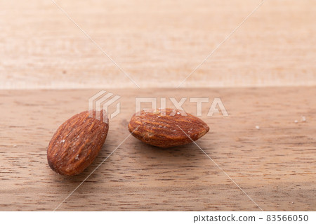 Almond walnut material and nuts placed on a wooden table Almond walnut material and nuts placed on a wooden table 83566050