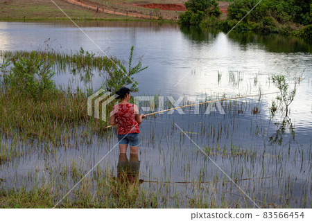 Itaja, Goias, Brazil - 10 15 2021: Elderly woman fishing Itaja, Goias, Brazil - 10 15 2021: Elderly woman fishing 83566454