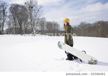 A young woman standing with a snowboard, a snowboard image A young woman standing with a snowboard, a snowboard image 83566461