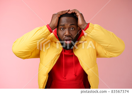 Shocked stupefied young african-american bearded man grab head drop jaw gasping confused frustrated looking upset troubled have problems standing stunned concerned pink background 83567374