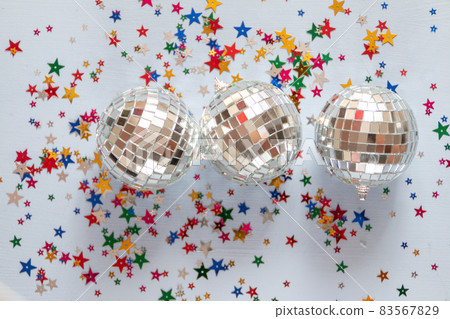 Disco ball on blue background with multicolored stars confetti Disco ball on blue background with multicolored stars confetti 83567829