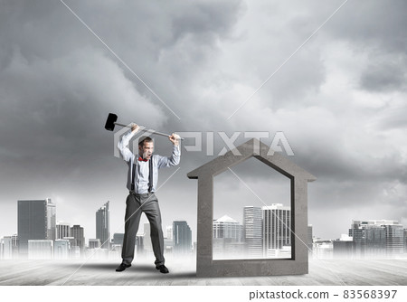 Manager man crashing stone home as symbol for real estate insurance 83568397