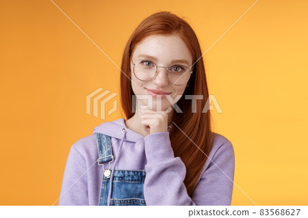 Confident happy relaxed european redhead skillful young female entrepreneur glasses establish startup smiling delighted look pleased result touch chin thoughtful smart, orange background Confident happy relaxed european redhead skillful young female entrepreneur glasses establish startup smiling delighted look pleased result touch chin thoughtful smart, orange background 83568627