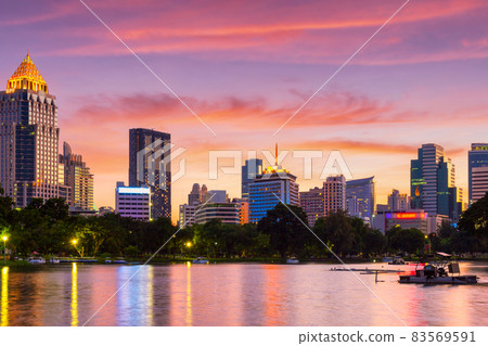 Nature lake in public park at city center with business buildings and sunset sky background, Bangkok 83569591