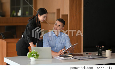 Businessman showing financial performance report via touchpad to his manager 83569815