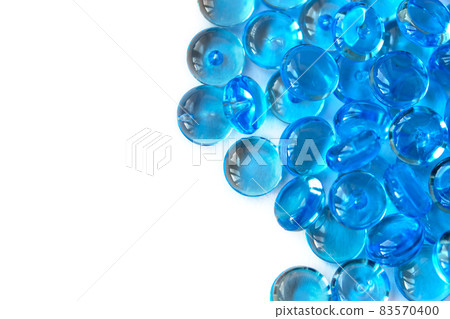 Transparent blue glass marble beads isolated on white background. Acrylic ice stones for decoration. Water drops. Abstract wallpaper or backdrop for web design Transparent blue glass marble beads isolated on white background. Acrylic ice stones for decoration. Water drops. Abstract wallpaper or backdrop for web design 83570400