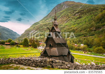 Borgund, Norway. Famous Landmark Stavkirke An Old Wooden Triple Nave Stave Church In Summer Day. Ancient Old Wooden Worship In Norwegian Countryside Landscape Borgund, Norway. Famous Landmark Stavkirke An Old Wooden Triple Nave Stave Church In Summer Day. Ancient Old Wooden Worship In Norwegian Countryside Landscape 83570565