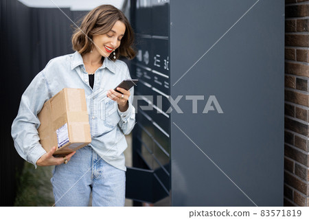 Caucasian woman with parcel near post terminal 83571819