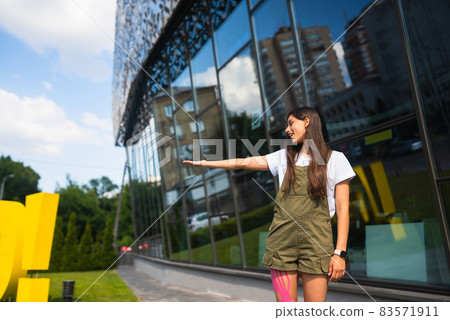 Young woman on the street shows something on the side Young woman on the street shows something on the side 83571911