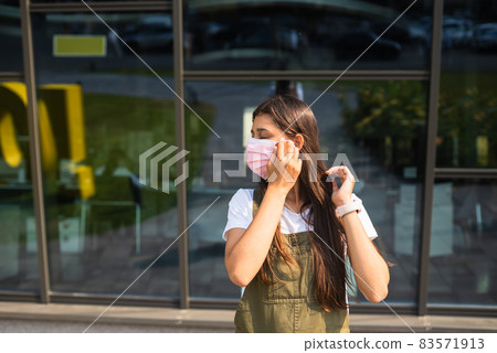 Young woman putting on protective mask for coronavirus prevention. Young woman putting on protective mask for coronavirus prevention. 83571913