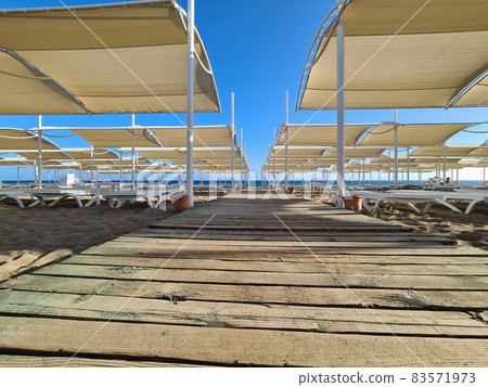 Wooden deck on a sandy beach, road to the sea 83571973