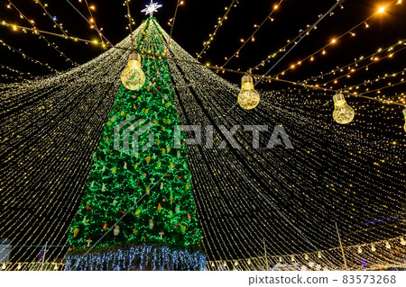Beautiful scenic decorated Christmas Tree with decorations and illuminated by light garlands against Sophia Cathedral on background Sofievska square market. Happy 2022 New Year and xmas Celebration 83573268