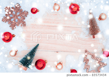 Xmas background table. Winter wooden decoration backdrop. Christmas board with old rustic wall, white frozen snow, golden balls and gift box. Minimal flat lay. Xmas background table. Winter wooden decoration backdrop. Christmas board with old rustic wall, white frozen snow, golden balls and gift box. Minimal flat lay. 83573434