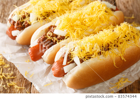 Cincinnati fast food chili hot dog with beef sausage, cheddar cheese and onions close-up. horizontal 83574344