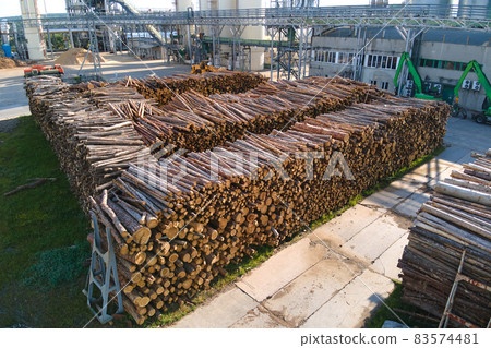Aerial view of wood processing factory with stacks of lumber at plant manufacturing yard. Aerial view of wood processing factory with stacks of lumber at plant manufacturing yard. 83574481
