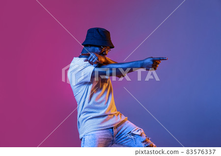 Winning success happy man celebrating being a winner. Dynamic image of male model on gradient purple pink studio background in neon 83576337