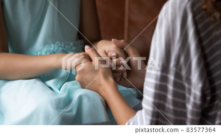 Young mom holding daughters hands, talking to kid Young mom holding daughters hands, talking to kid 83577364