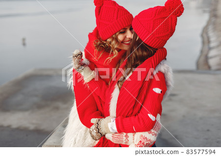 Mother and child in knitted winter hats play in winter park 83577594