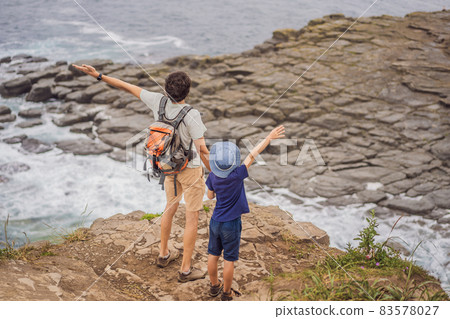 Dad and son tourists on the background of beautiful rocks and the sea. Hiking concept. Tobizin cape. Vladivostok, island Russky. Sea of Japan. Primorye. Primorsky krai. Nature of Russia. Tourism and 83578027