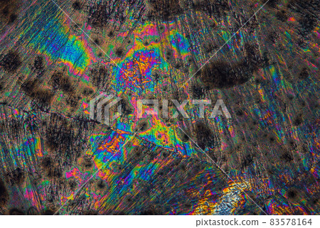 Extreme macro photograph of Vitamin C crystals forming abstract modern art patterns, when illuminated with polarized light, under a microscope objective with 10x magnification 83578164